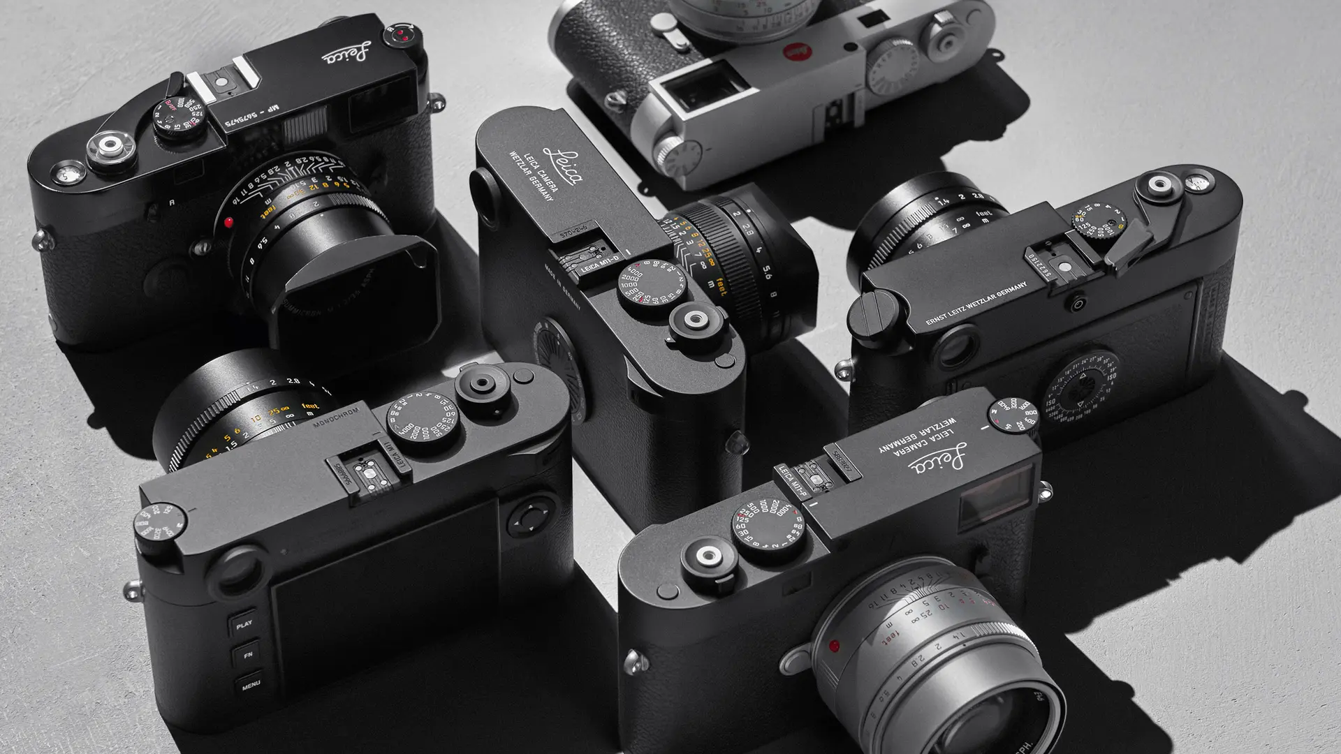 Top view of several Leica cameras on a gray background