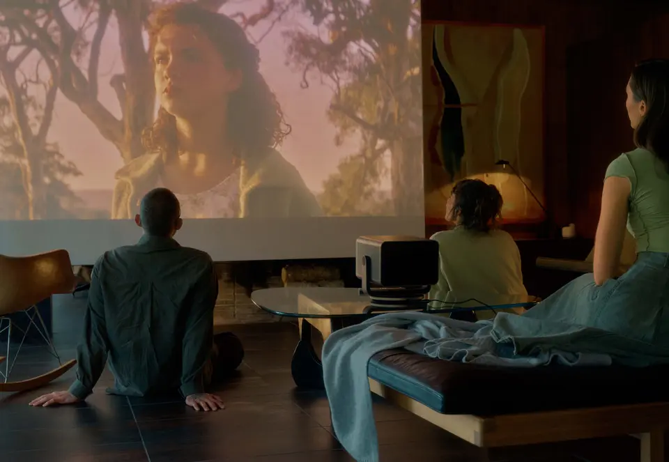 Few people sitting in a room watching a Leica Cine Play 1 projection.