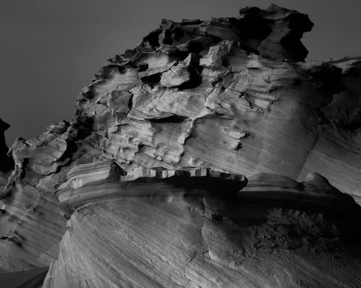 Black and white photography of jagged rock formations in a barren landscape