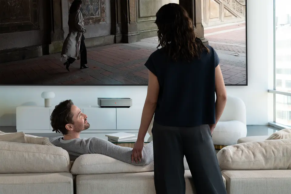 A man and a woman in front of a Leica Cine 1 projection.