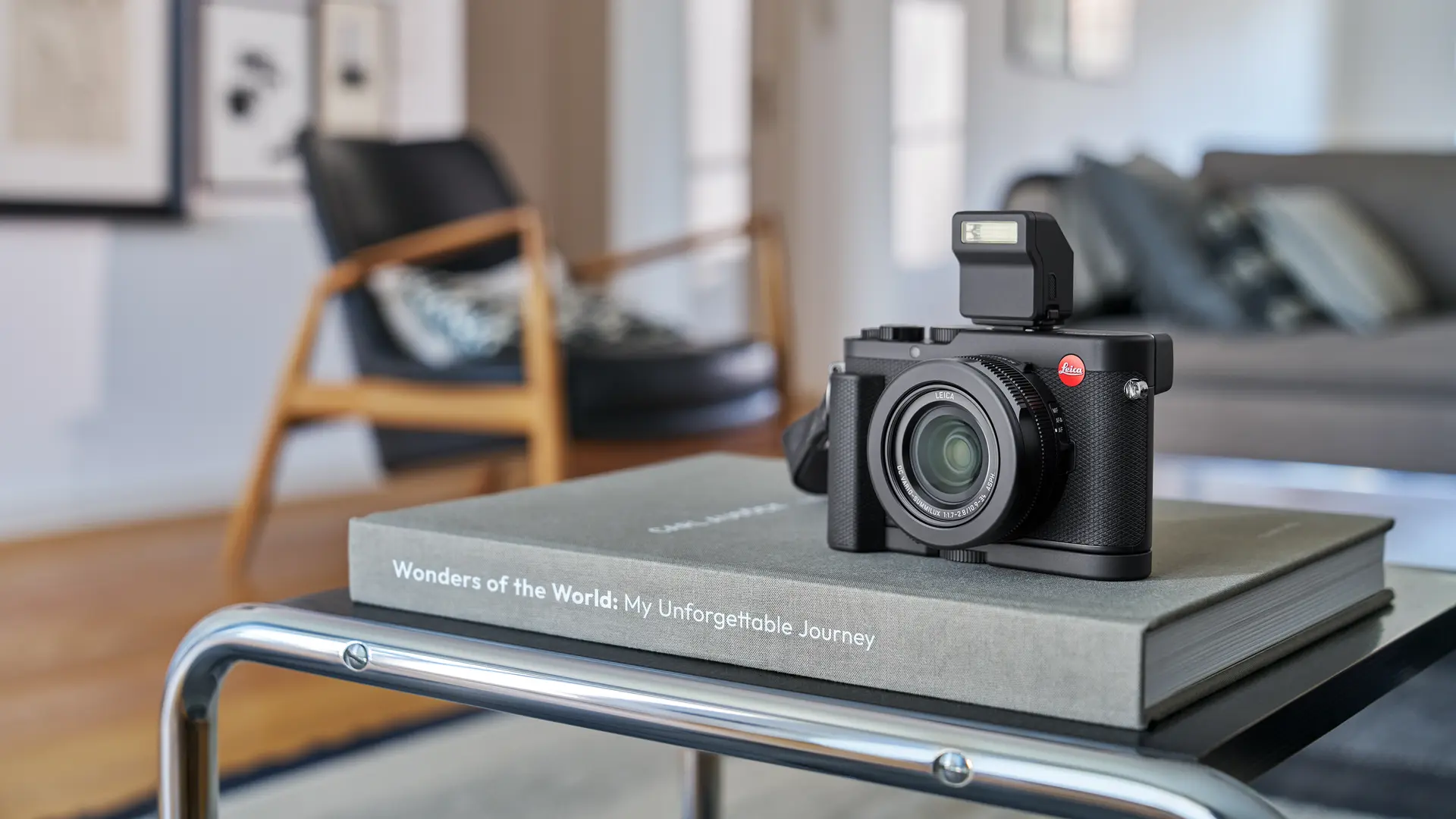 Leica D-Lux 8 placed on a book lying on a table.