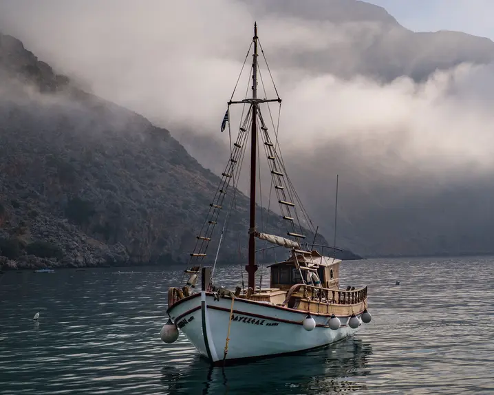 A sailing ship on the sea in front of an island