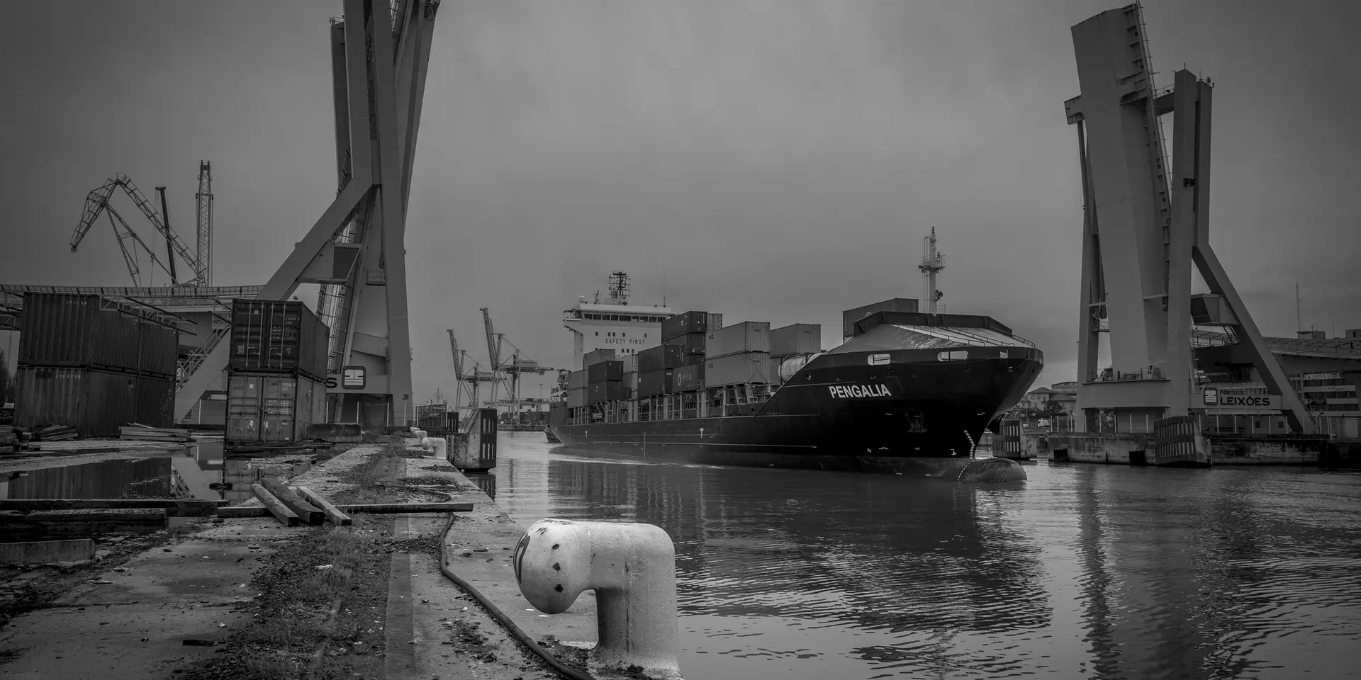 Container ship in the harbour, surrounded by cranes and containers
