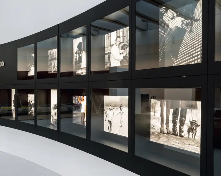 An exhibition of black and white photographs of famous events, presented in two curved rows.