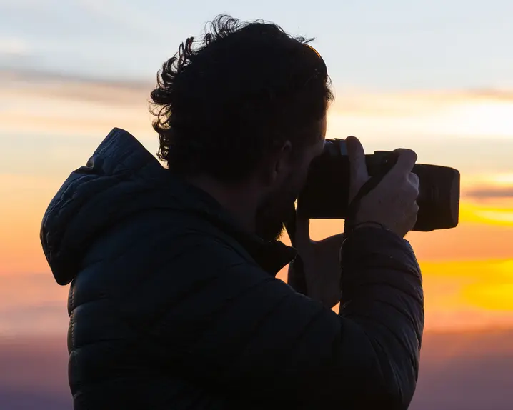 A photographer takes a photo of the sunset.