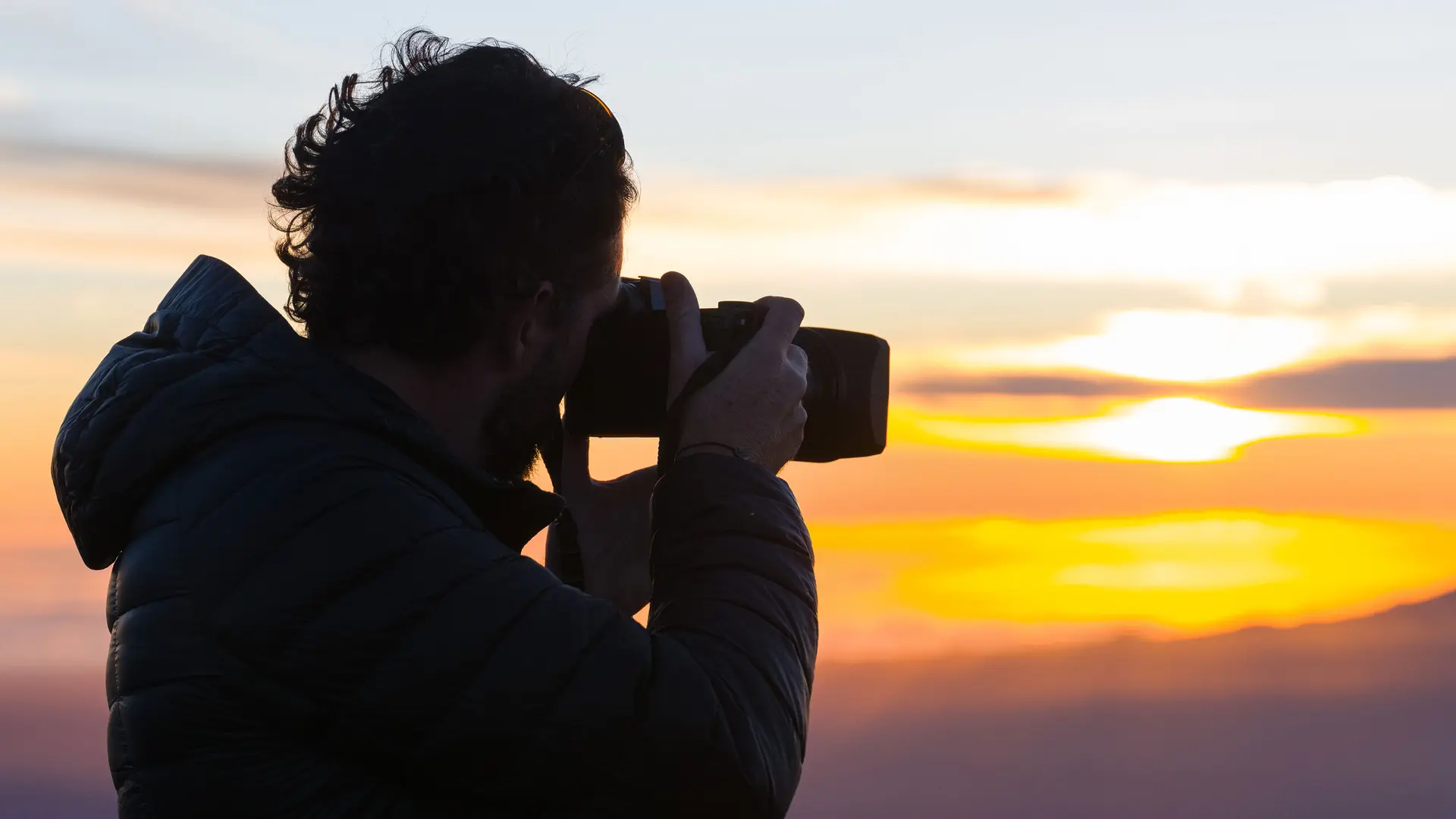 A photographer takes a photo of the sunset.